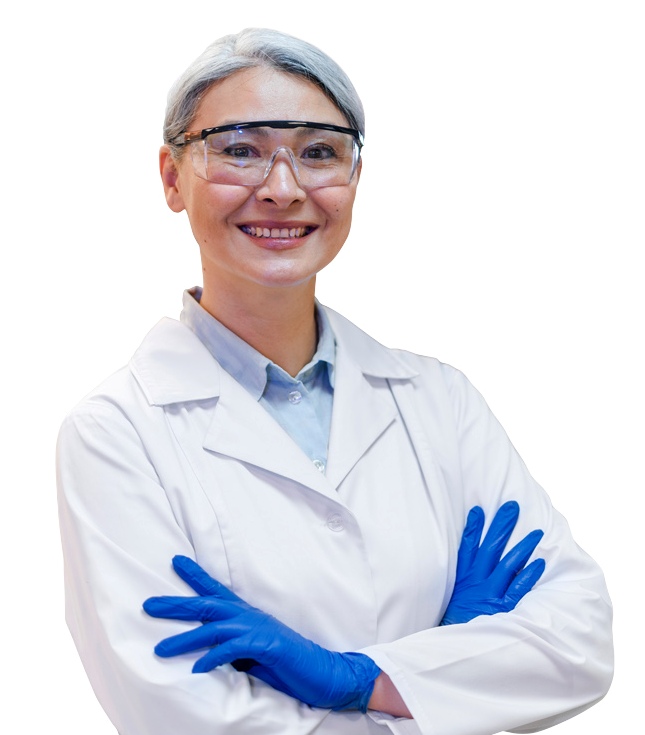 gray-haired woman in a lab coat wearing safety glasses and gloves