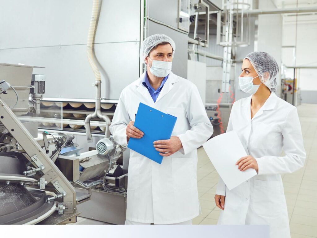man and woman in white lab coats inspecting a GMP certified manufacturing facility in the USA